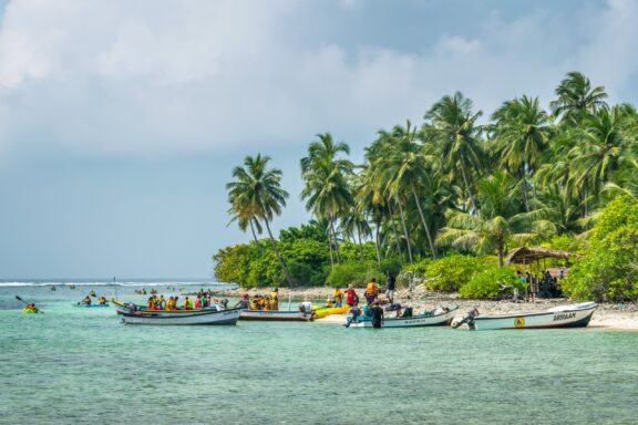 People and boats in the water next to Kapeni Island.