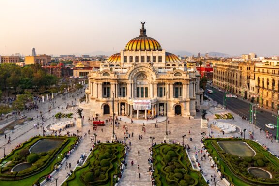 An aerial view of the Palace of Fine Arts during golden hour in Mexico City, Mexico.