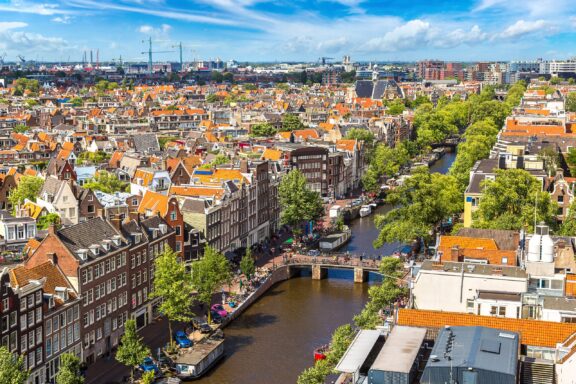 An aerial view of a canal and the surrounding city in Amsterdam, Netherlands.