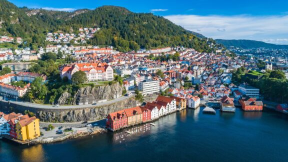 An aerial view of buildings, trees, and water in Bergen, Norway, one of the richest countries in Europe.