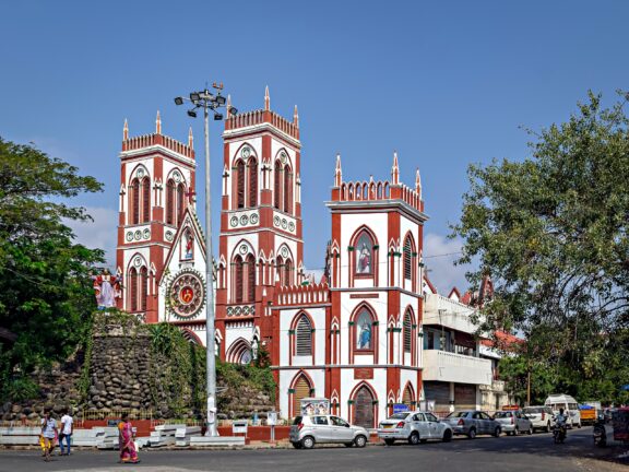 A red-and-white cathedral stands at an intersection in Puducherry, India.