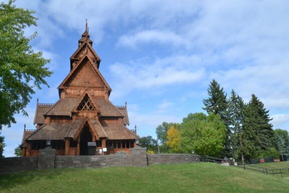 A ground-level view of a large wooden church in Scandinavian Heritage Park in Minot, North Dakota.