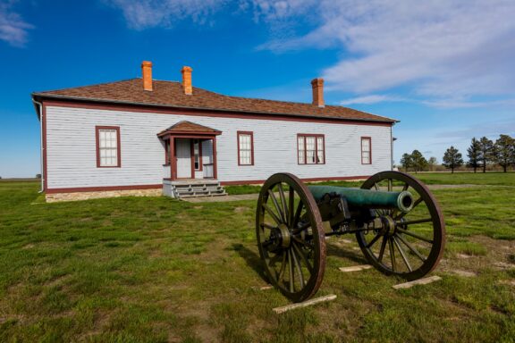 A canon sits on the grass in front of a building in Williams County’s Fort Buford State Historic Site.