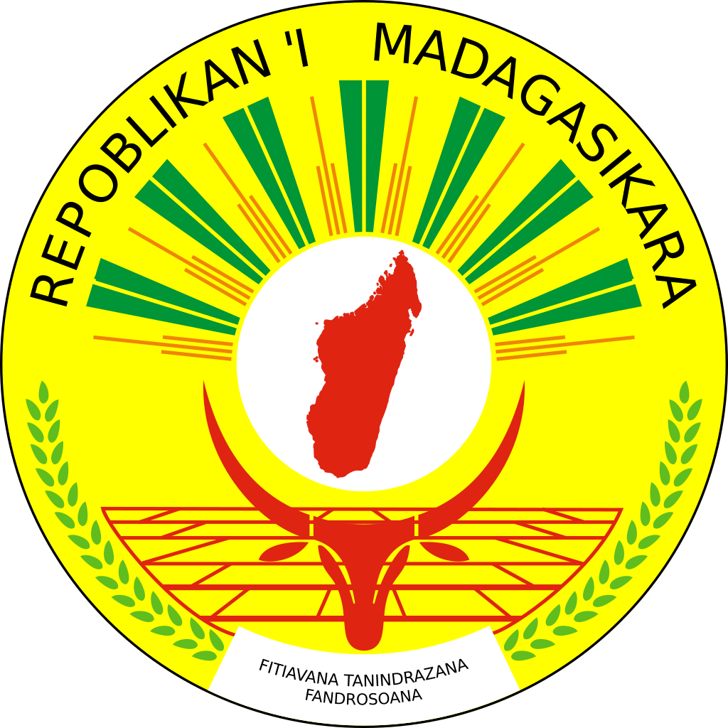 Coat of arms of Madagascar featuring a red outline of the island, a green and yellow emblem with a white disc, and Malagasy text.