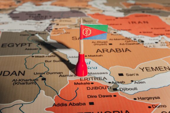 A pin with the flag of Eritrea placed on Eritrea's location on a world map.