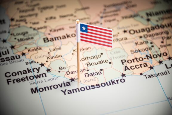 A pin with the Liberian flag placed on Monrovia on a map of Africa.