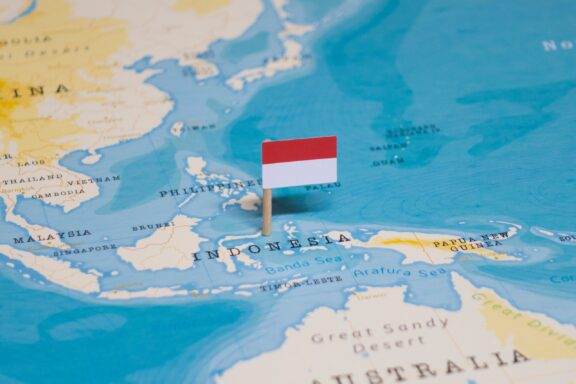 A pin with the flag of Indonesia placed on Jakarta on a world map.