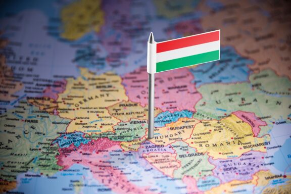 A Hungarian flag pin placed on a map, highlighting Hungary's location.