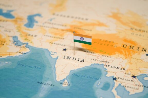 A pin with the flag of India placed on a map at the location of India.