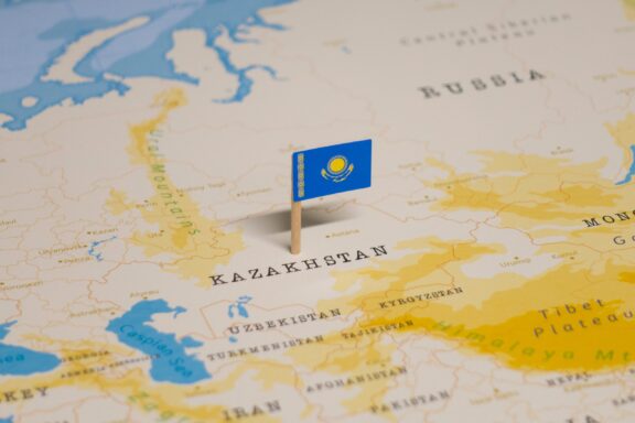 A pin with the flag of Kazakhstan placed on a map showing the country's location.