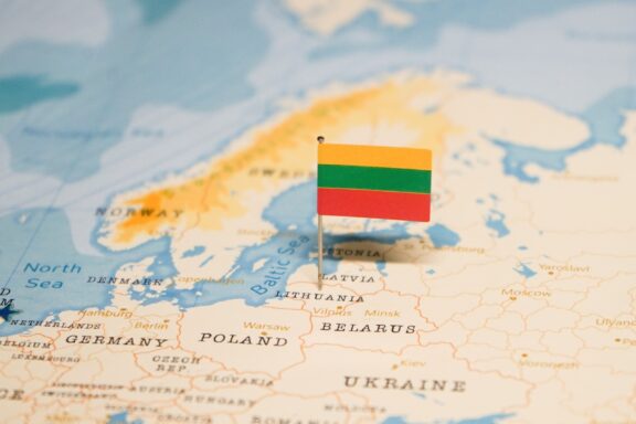 Lithuanian flag placed on a map showing Lithuania's location in Europe.