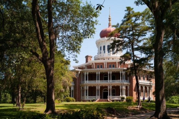 A view of a large, octagon-shaped building between trees in Mississippi’s Adams County.