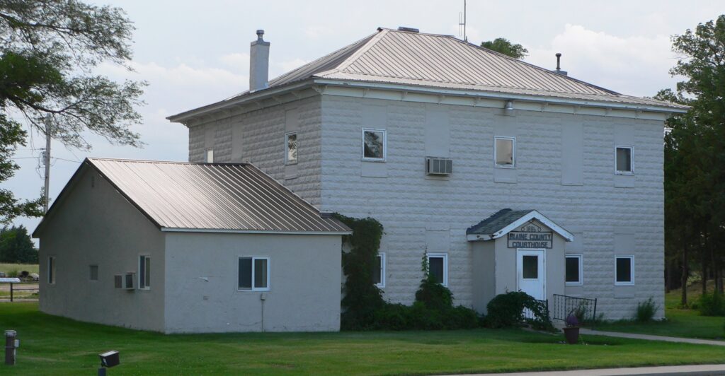 The Blaine County Courthouse sits in grass in Brewster, Nebraska.  