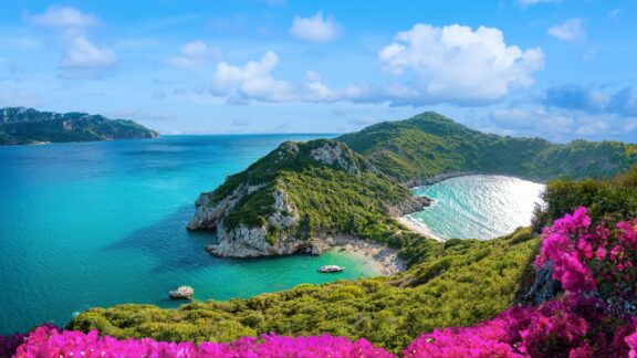 Porto Timoni Beach can be seen from atop a hill on the island of Corfu on a sunny day.