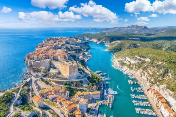 An aerial view of Bonifacio, surrounded by turquoise waters on the Mediterranean island of Corsica.