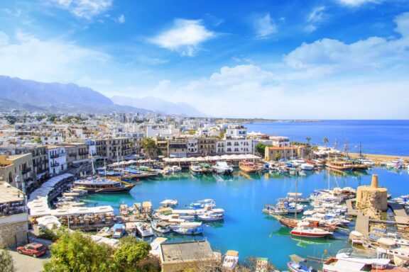 Boats are docked at a small harbour in North Cyprus on a sunny day.