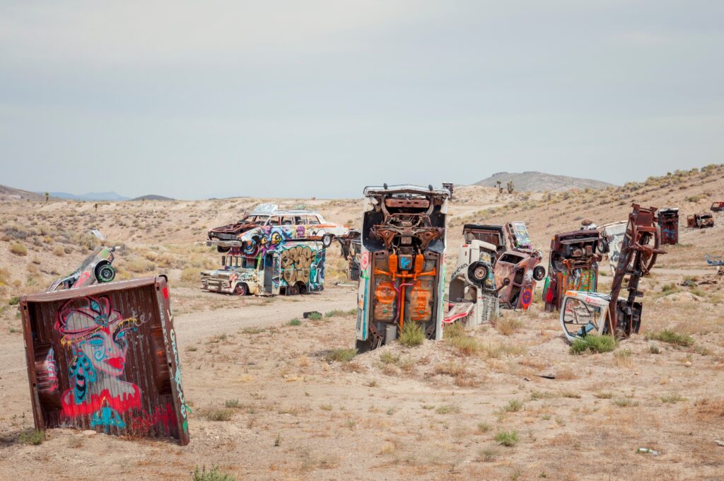 Many old vehicles stand vertically, half buried in the earth in Esmerelda County, Nevada.