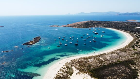 An aerial view of white sand beaches and surrounding blue waters.