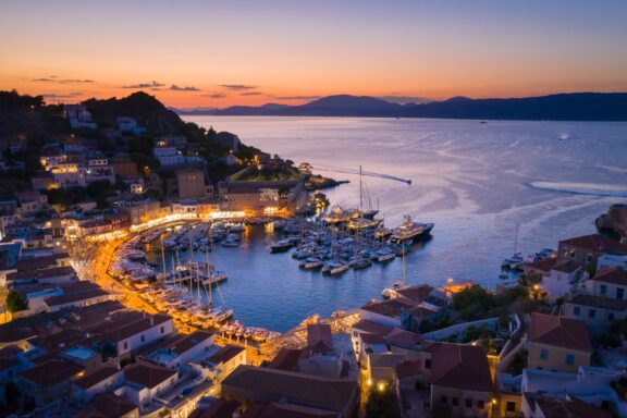 An aerial view of a small bay illuminated at night on Greece’s island of Hydra.