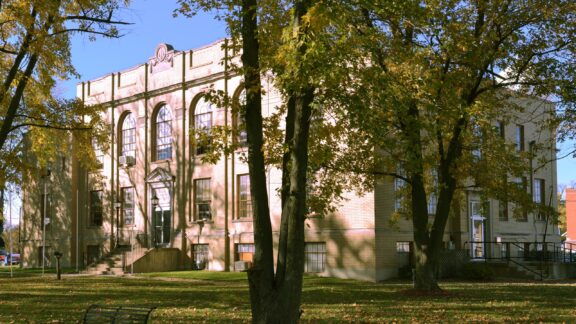 A view of the façade of the Knox County Courthouse in Edina, Missouri, surrounded by trees.