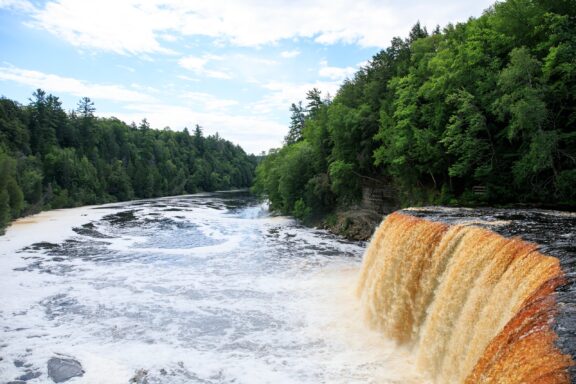 A waterfall flows between trees in Luce County, Michigan.  