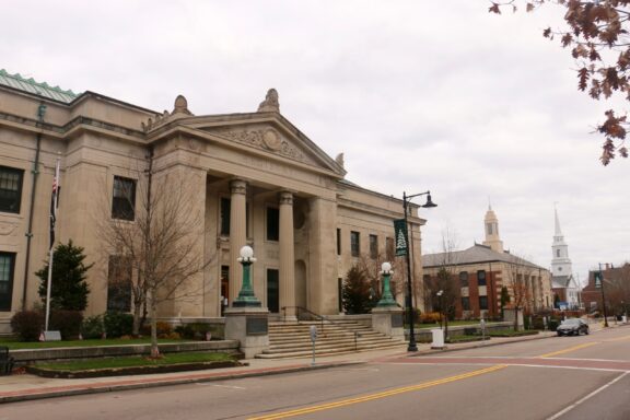 A street-level view of the Norfolk County Registry of Deeds building on a cloudy day.