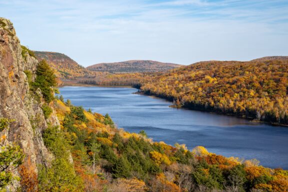 Trees with yellow and orange leaves surround the Lake of the Clouds in Porcupine Mountains State Park, Michigan.