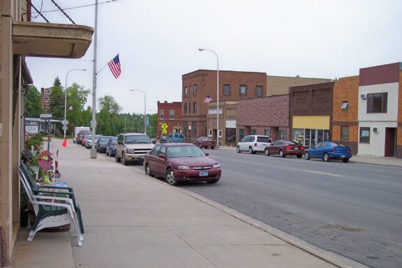 Cars line a main avenue on a cloudy day in Red Lake Falls, Minnesota.