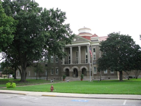 A street-level view of the Sharkey County Courthouse partly obscured by trees.