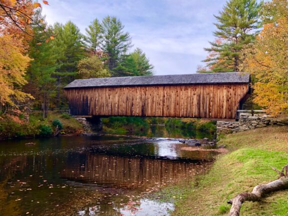 A wooden covered bridge extends over a small river in New Hampshire’s Sullivan County.