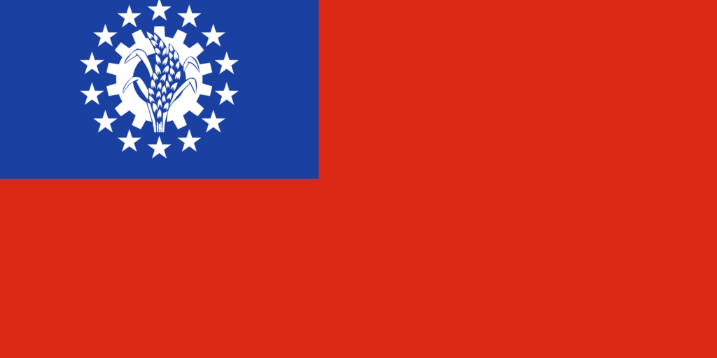 Flag of the Socialist Republic of the Union of Burma with a blue canton featuring a white cogwheel and rice plant surrounded by 14 white stars on a red field.