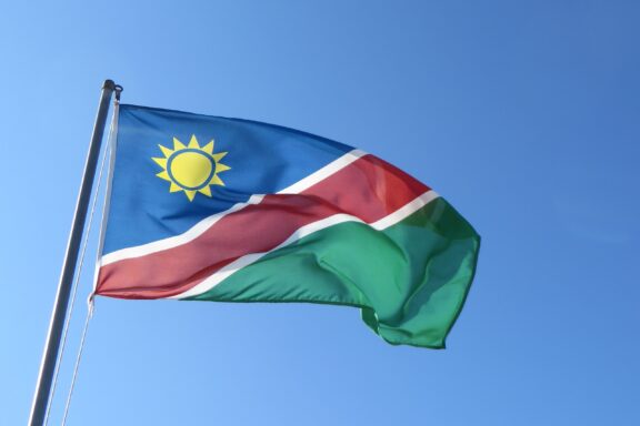 Flag of Namibia waving against a clear blue sky.