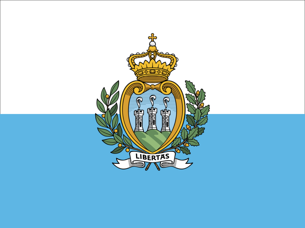 Flag of San Marino with a blue and white background and the national coat of arms in the center featuring three towers on a green mountain, a crown, and a scroll with the word "LIBERTAS".