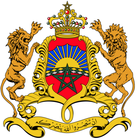 Coat of arms of Morocco featuring a red shield with a green pentagram, flanked by two lions, and topped with a crown, set against a blue background with a sunburst, and a scroll with Arabic script below.