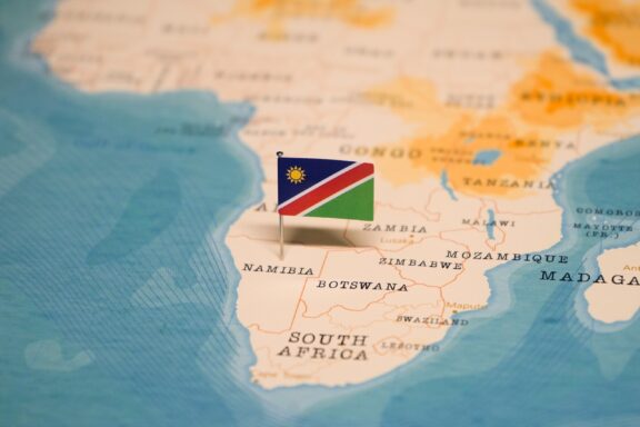 A pin with the flag of Namibia placed on Namibia's location on a colorful map of southern Africa.