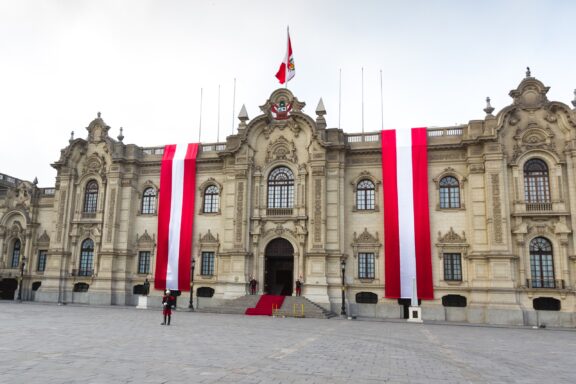 Peruvian flag banners hanging in front of the Government Palace in Lima.