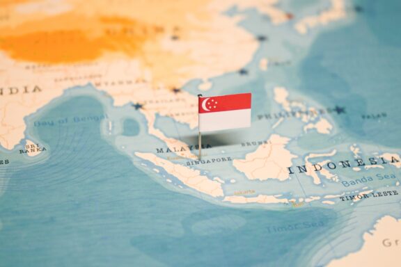 Singapore flag pinned on a world map showing its location.