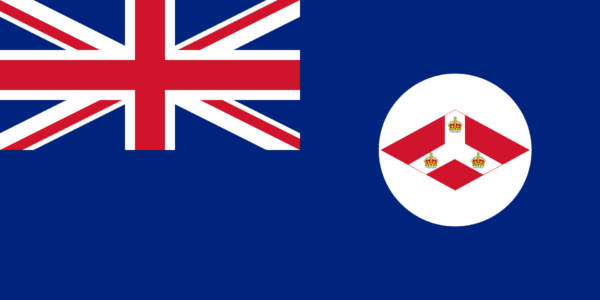 Flag of the Straits Settlements with a Union Jack in the top left corner and a blue field with a white circle containing red and white crests on the right.