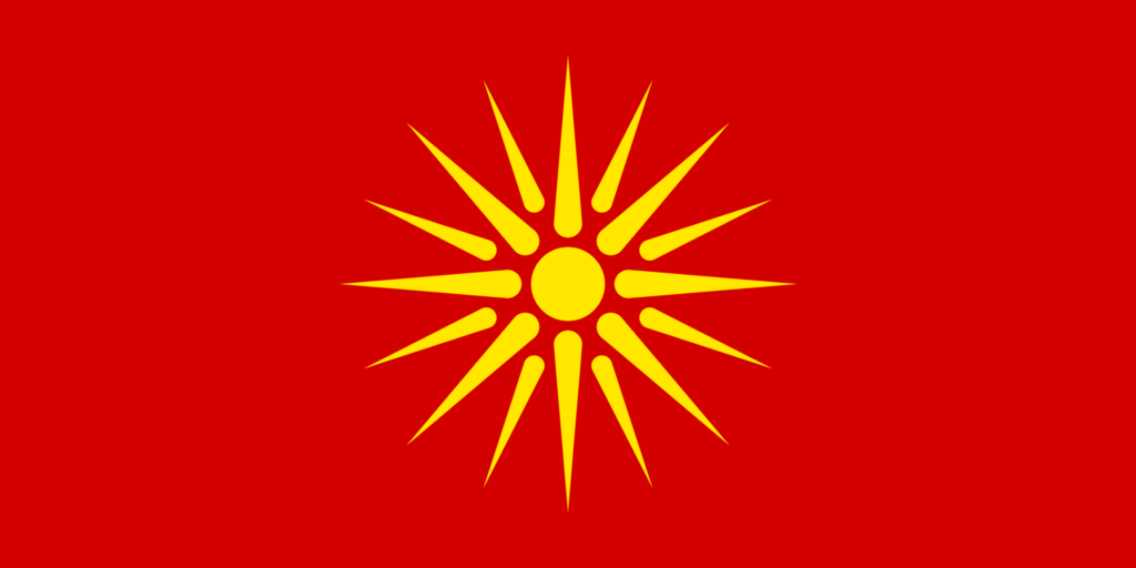 Red flag with a stylized yellow sun with eight extended and eight shorter rays centered on it.