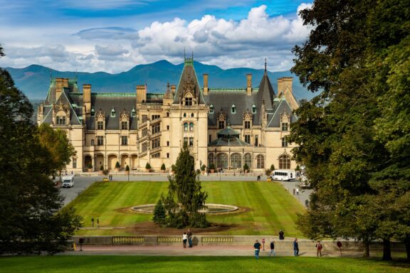 A view of the Biltmore Estate, framed by trees, in Asheville, North Carolina.