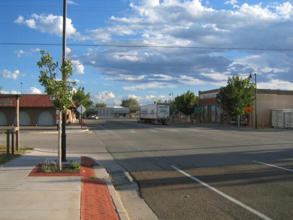 A lone truck drives through downtown Fort Sumner during the daytime.