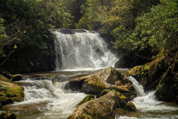 ater flows over rocks at the tree-covered Yellow Creek Falls in Graham County, North Carolina.