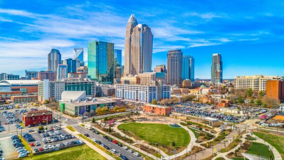 The skyline of downtown Charlotte, North Carolina rises behind a park in Mecklenburg County.