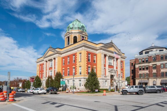 A low-angle view of the Monroe County Courthouse and an American flag.