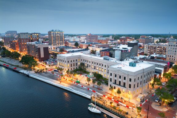 An aerial view of the Wilmington, North Carolina cityscape lining the water.