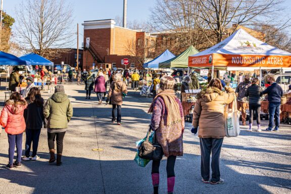 People gather at a farmers market on a cold winter day in Carrboro, North Carolina.