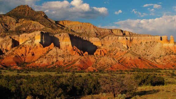 A large sandstone formation catches the golden hour light in Abiquiu, New Mexico.