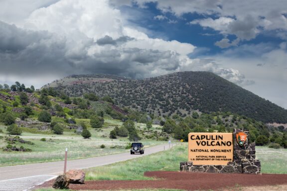 A car drives past a sign to the entrance of the Capulin Volcano National Monument in New Mexico’s Union County.