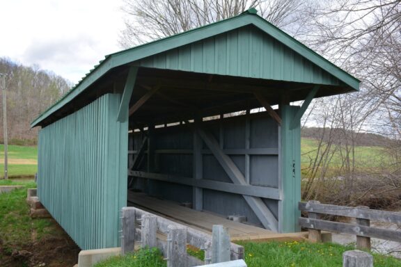 A green wooden bridge spans a stream in Vinton County, Ohio.