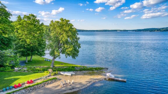 A park with trees and a small dock line Keuka Lake in Yates County.